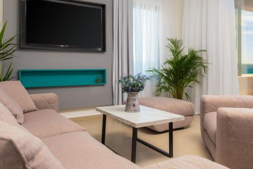 a living room with two chairs and a tv at Villa Four Brothers - Middle Floor in Podstrana