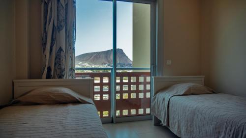 エル・メダノにあるOkeanos sea view 2 bedrooms VR-Mのベッドルーム1室(ベッド2台付)が備わり、山の景色を望めます。