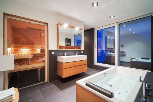 a bathroom with a tub and a sink and a bath room at Loft Rebhalde in Nonnenhorn