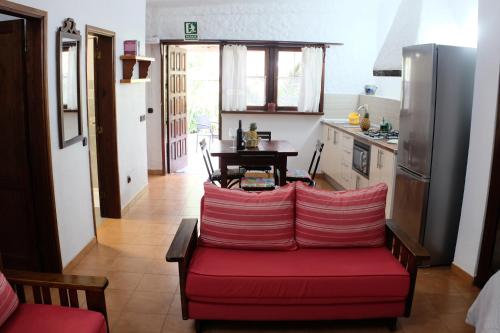 a living room with a red couch in a kitchen at Apartamentos Finca Wapa in Frontera