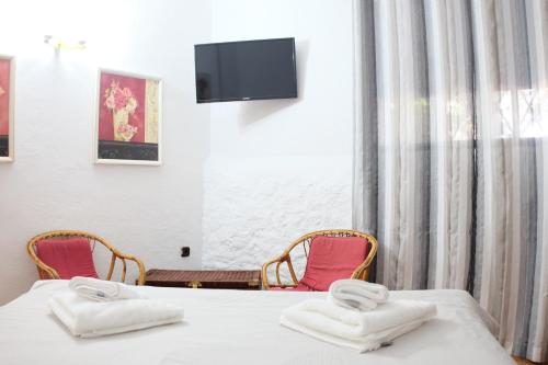 a room with two beds and two chairs and a tv at Apartamentos Finca Wapa in Frontera