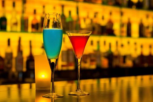 two wine glasses sitting on top of a bar at The Royal Park Hotel Iconic Tokyo Shiodome in Tokyo