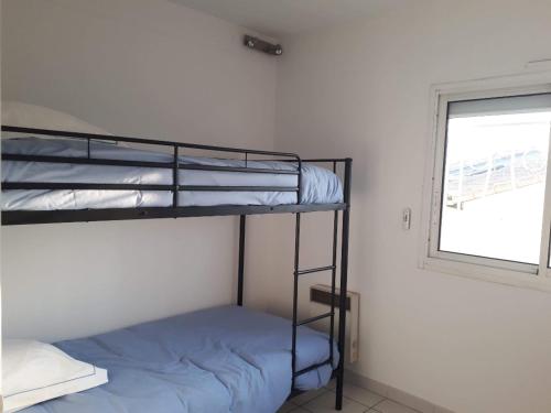 une chambre avec deux lits superposés et une fenêtre dans l'établissement Appart ARCAIM, climatisé 90m2, 4 chambres, à 200m de la plage, à Argelès-sur-Mer