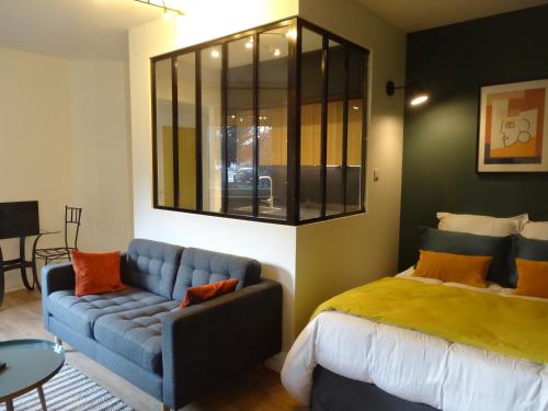 une chambre avec un lit et un canapé bleu dans l'établissement La vie est Belle, à Sélestat