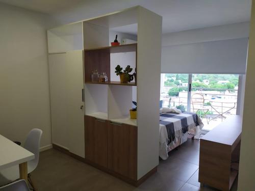 a bedroom with a bed and a large window at Departamento Parque Alem in Rosario