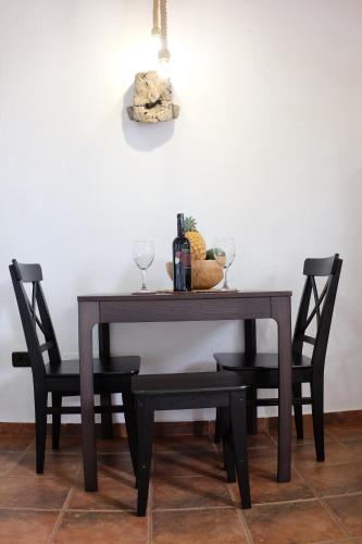 a table with two chairs and a bottle of wine at Apartamentos Finca Wapa in Frontera