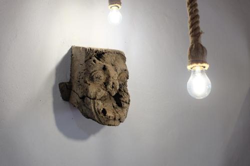 a light bulb and a rock on a wall with a lamp at Apartamentos Finca Wapa in Frontera