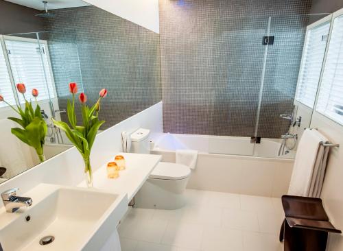 a bathroom with a sink and a toilet and a tub at Pestana Cidadela Cascais - Pousada & Art District in Cascais