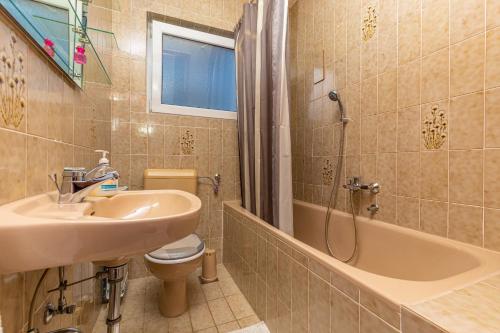 łazienka z umywalką, toaletą i wanną w obiekcie Vacattio apartments w Crikvenicy
