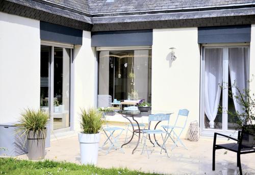a patio with a table and chairs on it at Ailes et Iles in Pleudaniel