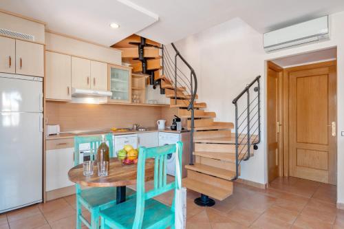 
a kitchen with a table, chairs, and a refrigerator at Pierre & Vacances Resort Fuerteventura OrigoMare in Lajares
