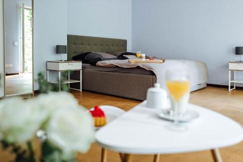 Sala de estar con 1 cama y 2 mesas con bebidas en Doppelzimmer an der TA (Nr. 1) en Hameln