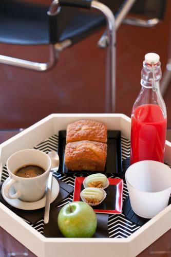 a tray with food and a cup of coffee and an apple at MyNavona in Rome