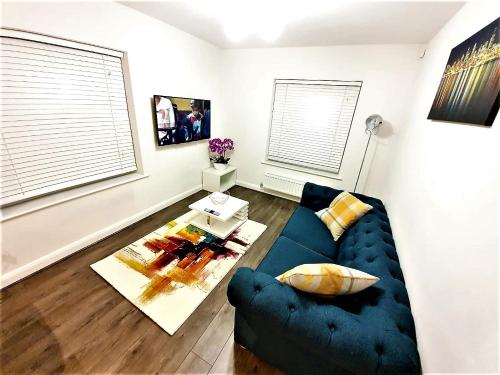 a living room with a blue couch and a table at Manchester Holiday Apartment in Manchester