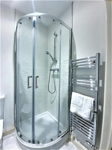 a shower with a glass door in a bathroom at Manchester Holiday Apartment in Manchester