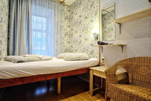 a small bedroom with a bed and a window at Mila Guest House in Moscow