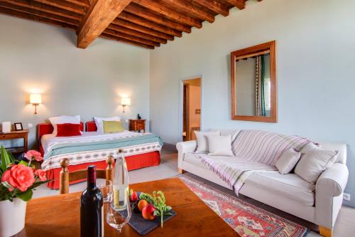a living room with a couch and a bed at Le Mas de Peint - Hôtel et Restaurant in Le Sambuc