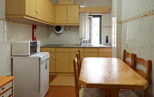 a small kitchen with a wooden table and a refrigerator at Abrigo da Montanha - Alojamento Familiar in Sabugueiro