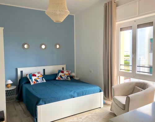 una camera blu con un letto e una sedia di Poetto Beach House-Molara Due a Cagliari