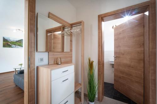 a bathroom with a wooden door and a sink at Ferienwohnung Riedmann in Söll
