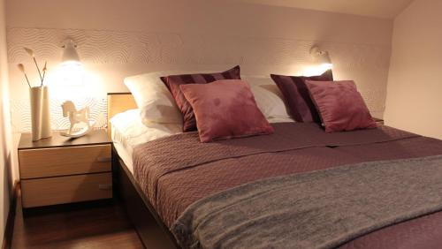 sypialnia z łóżkiem z białymi i czerwonymi poduszkami w obiekcie Koralia Domki i Apartamenty w Sarbinowie