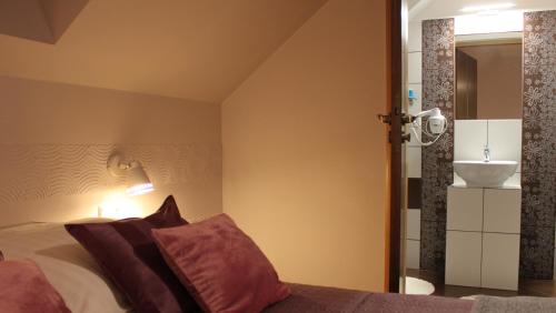 ein Schlafzimmer mit einem Bett und ein Badezimmer mit einem Waschbecken in der Unterkunft Koralia Domki i Apartamenty Basen z podgrzewaną wodą in Sarbinowo