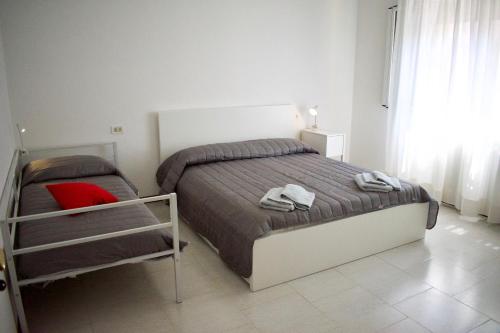 a small bedroom with a bed and a red pillow at App4rent - VILLA MIMOSA - 3 Family apartments - parking, wifi, near the beach in Lido di Jesolo