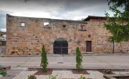 a large brick building with a large doorway at Casa Rural La Panera in Cillamayor