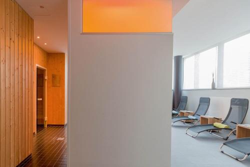 a row of chairs in an office with orange walls at Seminaris CampusHotel Berlin in Berlin