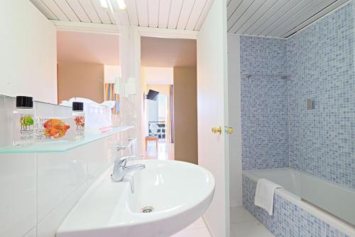 a bathroom with a sink and a bath tub at azuLine Hotel Pacific in San Antonio