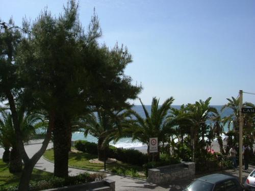 a view of a street with trees and the ocean at Taormina Beach House in Mazzeo