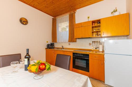 a kitchen with a table and a white refrigerator at Vacattio apartment 2 in Crikvenica