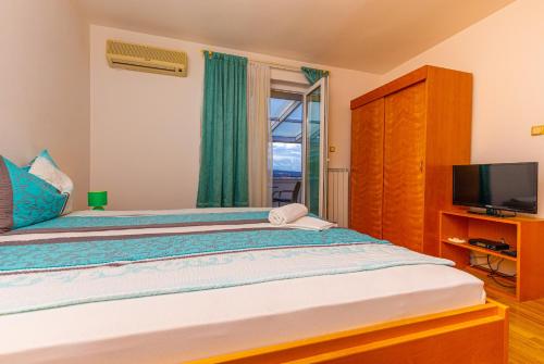 a bedroom with a large bed and a television at Vacattio apartment 2 in Crikvenica