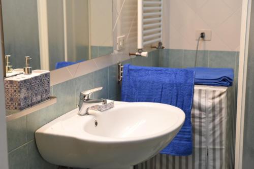ein Badezimmer mit einem weißen Waschbecken und blauen Handtüchern in der Unterkunft Casa Vacanze Mare Blue in Vietri