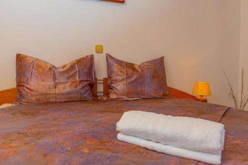 a bed with two pillows and a white towel on it at Vacattio apartment 2 in Crikvenica
