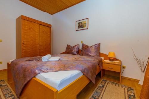 a bedroom with a large bed with a wooden headboard at Vacattio apartment 2 in Crikvenica