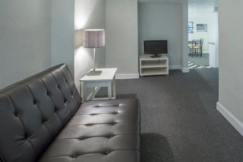 a living room with a couch and a television at Sabal Palms Inn in St Pete Beach