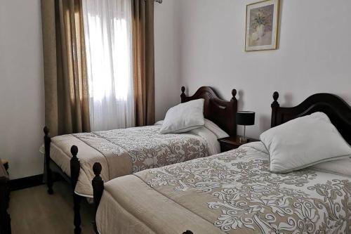 a bedroom with two beds and a window at VillaHouse in São Vicente