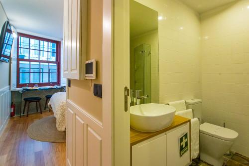 y baño con lavabo y aseo. en Charming Studio in Historic Downtown, en Oporto