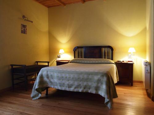 a bedroom with a bed and a table and a chair at Casa Rural Las Jañonas CC-CR-00219 in Gata
