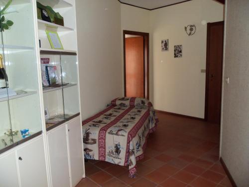a small room with a bed and a book shelf at Appartamento San Bastian in CastellʼAlfero