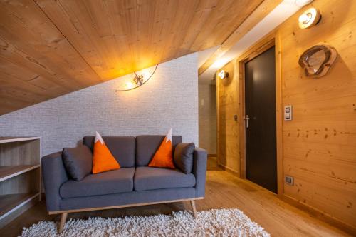 a living room with a blue couch with orange pillows at Hotel Base Camp Lodge - Bourg Saint Maurice in Bourg-Saint-Maurice