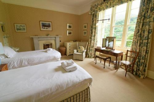una camera con 2 letti, una scrivania e una finestra di Chesthill House and Estate, Glen Lyon ad Aberfeldy