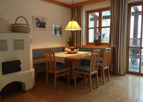 Landhäusl في ويسينسي: غرفة طعام مع طاولة وكراسي ومدفأة
