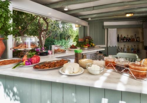 a kitchen with many different foods on a counter at Aegean Village in Parikia