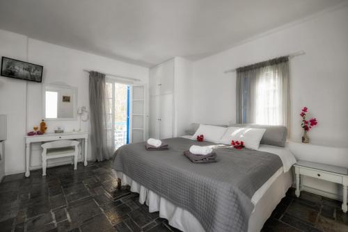 a bedroom with a large bed with two towels on it at Aegean Village in Parikia