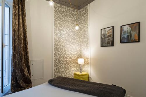 ジェノヴァにあるLa Dimora del Ducale by Wonderful Italyのベッドルーム1室(ベッド1台、ランプ、壁付)