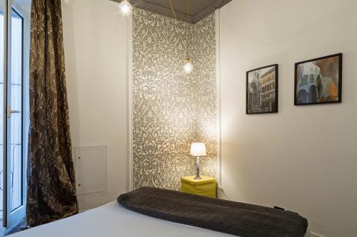 a bedroom with a bed and a lamp and a wall at La Dimora del Ducale by Wonderful Italy in Genoa