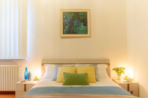 ein Schlafzimmer mit einem Bett mit gelben und grünen Kissen in der Unterkunft Little Gem in the city center in Florenz