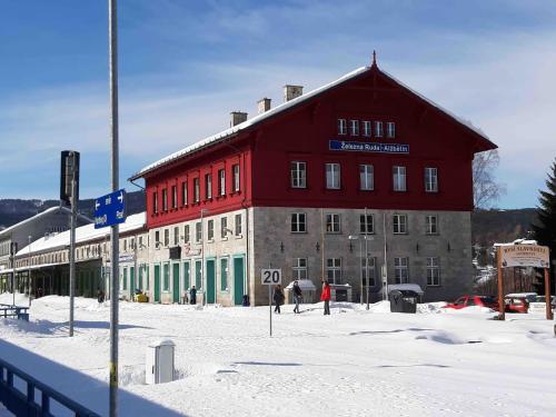 a large red and green building in the snow at Dopravna Alžbětín in Železná Ruda